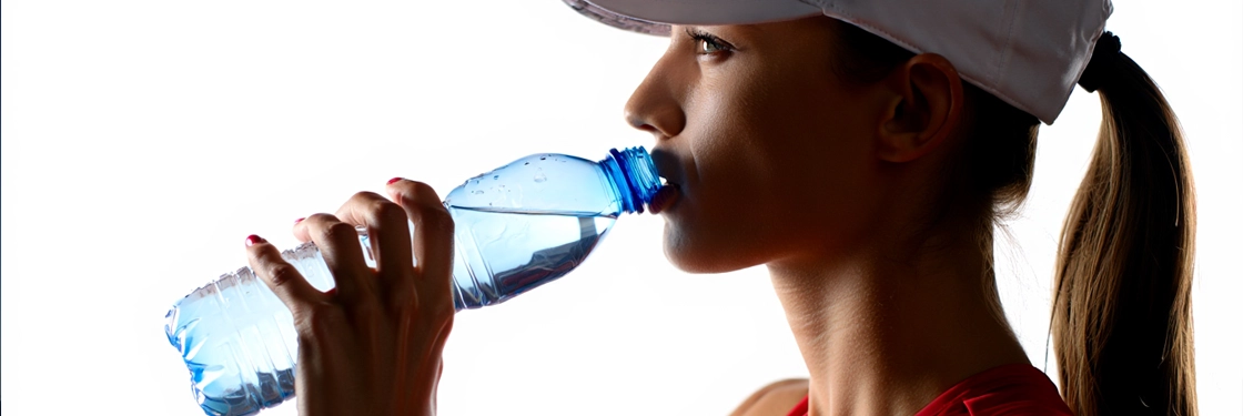 Девушка во время спортивных занятий, контолирует водный баланс